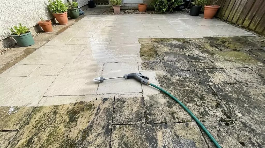 Jetterix cleaning a stone patio — half clean, half covered in moss and mildew